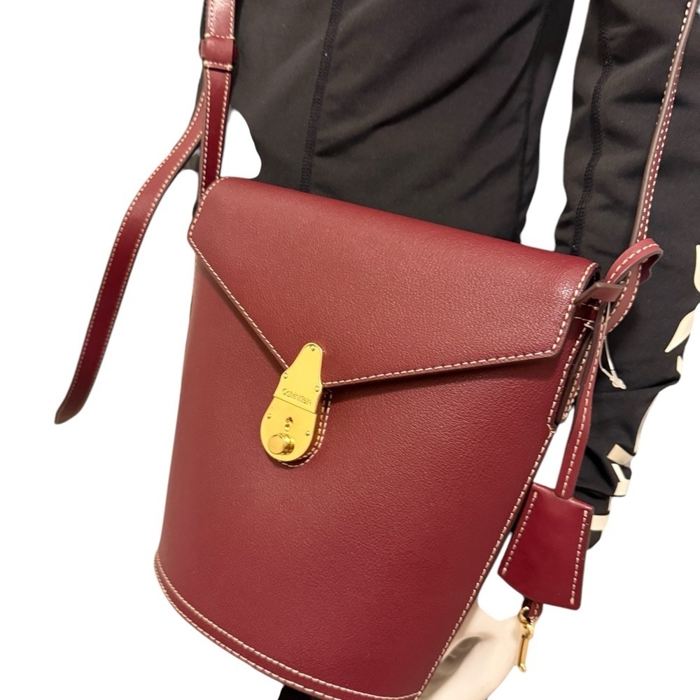 Calvin Klein Statement Series
Lock Flap Merlot Leather Bucket
Crossbody Bag/ new